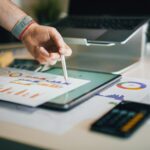 person using stylus on tablet with charts
